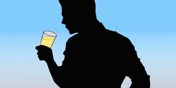 A figure of a person holding a glass