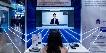 woman, black hair, screen, talks to AI asian assistant in suit. baby blue lasers, well lit room