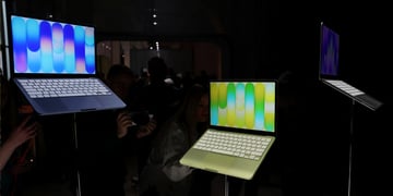 2 Apple MacBooks, left one blue, purple screen, right one green, orange screen, slightly lower