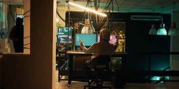 man in grey hoody, computer screens, hands up, happiness, 