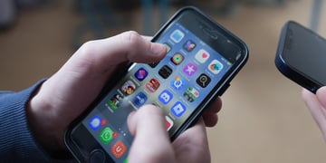Person holds iPhone in their hands with app screen visible