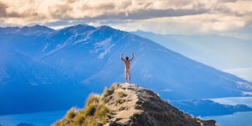 naked man on top of mountain, hands up, white clouds, grass, blue mountains, light blue sea