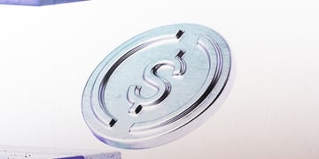 silver crypto token with dollar sign in middle, white background