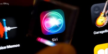 siri app icon on black smartphone screen, guitar on the right
