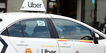 white uber car with sing on door, on top of roof