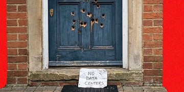 Thirteen bullet shots left in a door with a "No date Centers" note under the doormat.