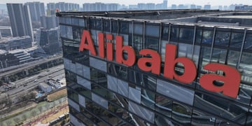 alibaba orange logo on top of dark glass building