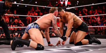 Wrestlers butting heads in the ring.