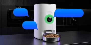 A smart cat feeder with a camera and blue speech bubbles