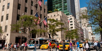 fifth avenue, sunny day, blue sky, tall buildings, pedestrians crossing street, yellow taxis,