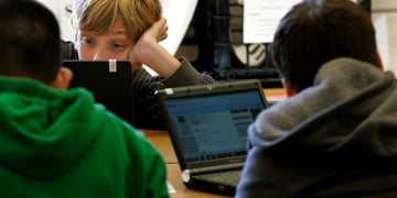 three young teens on black laptops, blonde buy, green jumper, screens, 