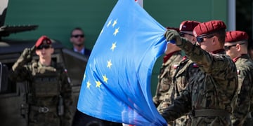 polish army men, war uniform, bordo hats, blue eu flag with yellow stars 