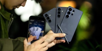three black samsung galaxy  26S Ultra smartphones held in one hand, black pen, 