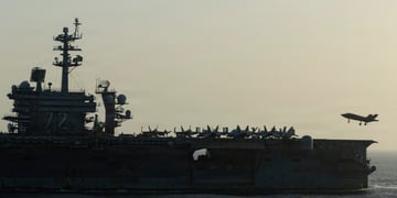 USS Abraham Lincoln (CVN 72) war ship at sea during sunset, plane in sky, plane fleet onboard,