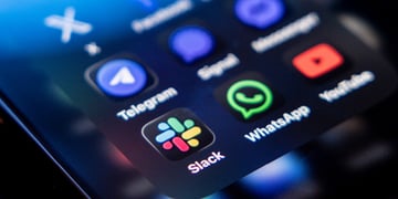 slack app icon next to whatsapp and telegram on dark smartphone screen