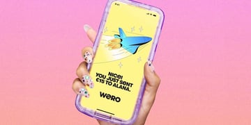 A hand holding a smartphone with a Wero app open, it says "You just sent €15 to Alana"