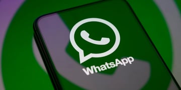 WhatsApp logo reflection on a smartphone's screen, green, white