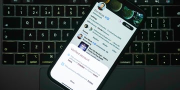 elon musk X premium account, blue verification check, black computer keyboard, phone screen