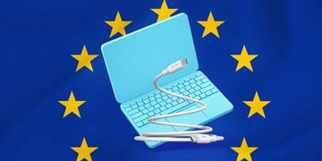 A laptop with a USB-C charger, European Union flag on the background