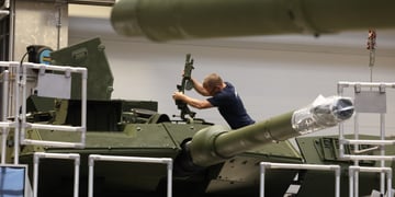 white man, machine gun, leopard 2A7 battle tank, indoors, blonde man