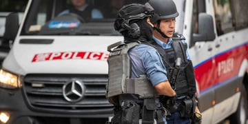 hong kong, two male policemen, white police van, blakc bulletproof vests, blue shirts, black helmet
