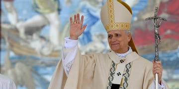 pope leo, dressed in white, silver cross in right hand, left hand up, old white man