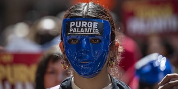 Anti-ICE demonstrator with mask saying "Purge Palantir"