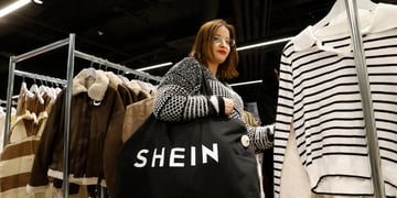 young woman, black shopping back, white shein sign, winter coat with white fur, black stripes