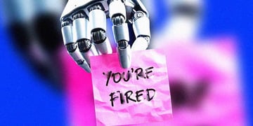 A robot's hand holding a note that says "You're fired"