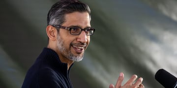 sundar Pichai, black and grey hair, glasses, indian man, grey background, black shirt