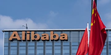 alibaba orange signage atop glass building, blue sky, white cloud, two china's flags
