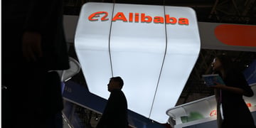alibaba booth, white glowy sign, orange letters, two black silhouettes of asian male and female