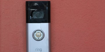 amazon ring doorbell camera, grey and black, red wall