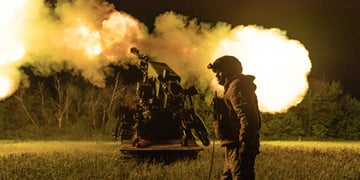 ukrianian soldier in uniform, helmet, white male, night time field, explosion artilery