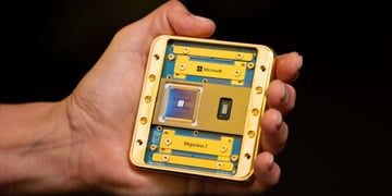 white male hand holds microsoft holden chip the size of fist, black background