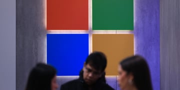 microsoft logo, red, green, blue, yellow squares, two white blurry women, one white blurry man.