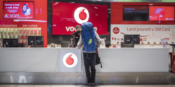 vodafone red kiosk, traveler in huge light blue backpack,, 