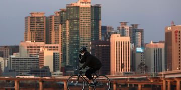 biker in seoul, tall buildings seen in the background