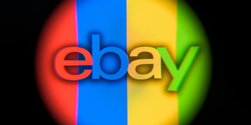 ebay logo in round shape that's in red, blue, yellow, green stripes, black background