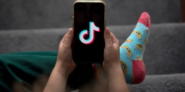A child holds a smartphone displaying the TikTok logo in an arranged photograph in Sydney, Australia