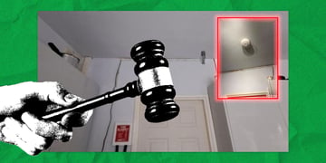 A hand holding a gavel, an AI-generated smoke detector in the corner of the room
