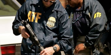 2 ATF agents wearing jackets with logo holding guns