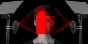 A woman's face lit up by two surveillance cameras