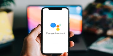 Hand holding phone with Google Assistant