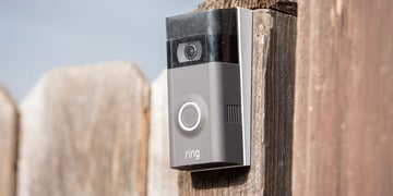 a Ring security camera fixed onto a fence