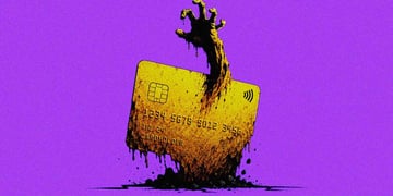 An expired credit card with a zombie-like hand reaching through it
