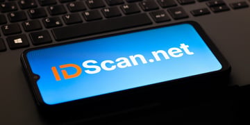 IDScan.net logo is on a smartphone screen, black keyboard in the back,