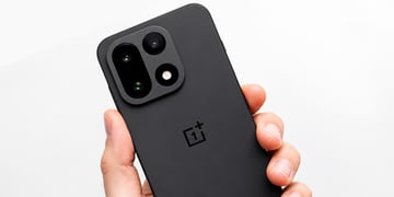 OnePlus 15 smartphone held in hand with a white backdrop