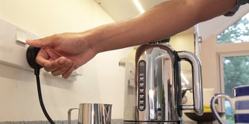 Person using electric kettle at home