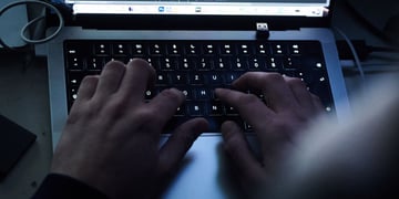 Hands typing on a computer keyboard.